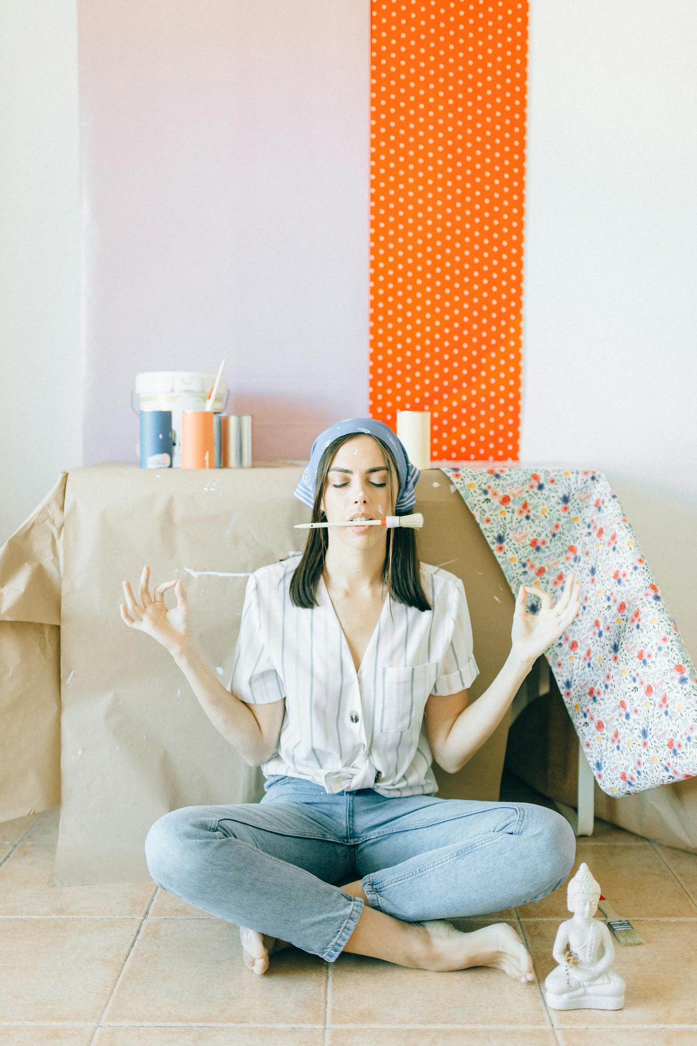 A young woman meditates amidst home renovation supplies, balancing calm and creativity.