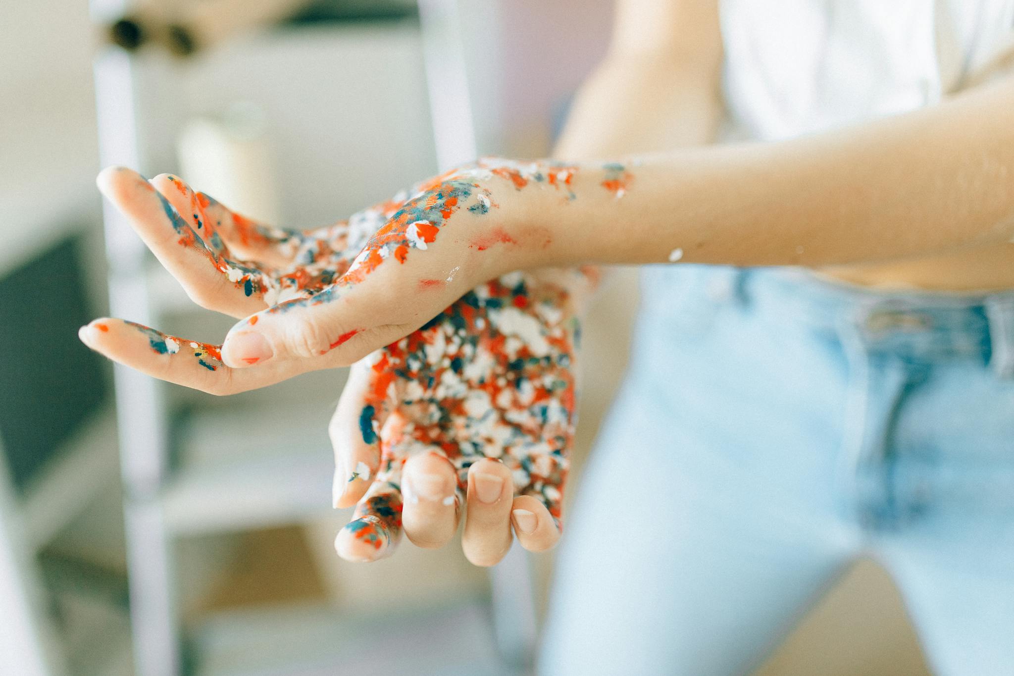 Vibrant paint-covered hands showcasing creativity and DIY fun indoors.